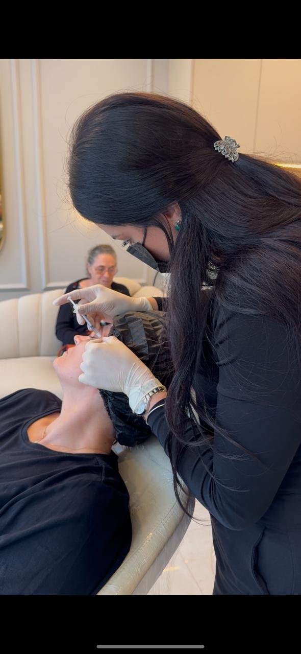 Dra. Natalia especialista em harmonização, aplicando botox em consultorio que também realiza implantes